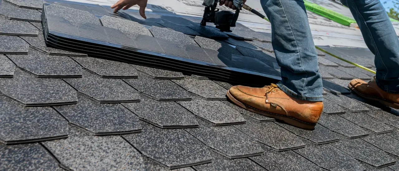 A Heritage roofer hand-nailing architectural shingles